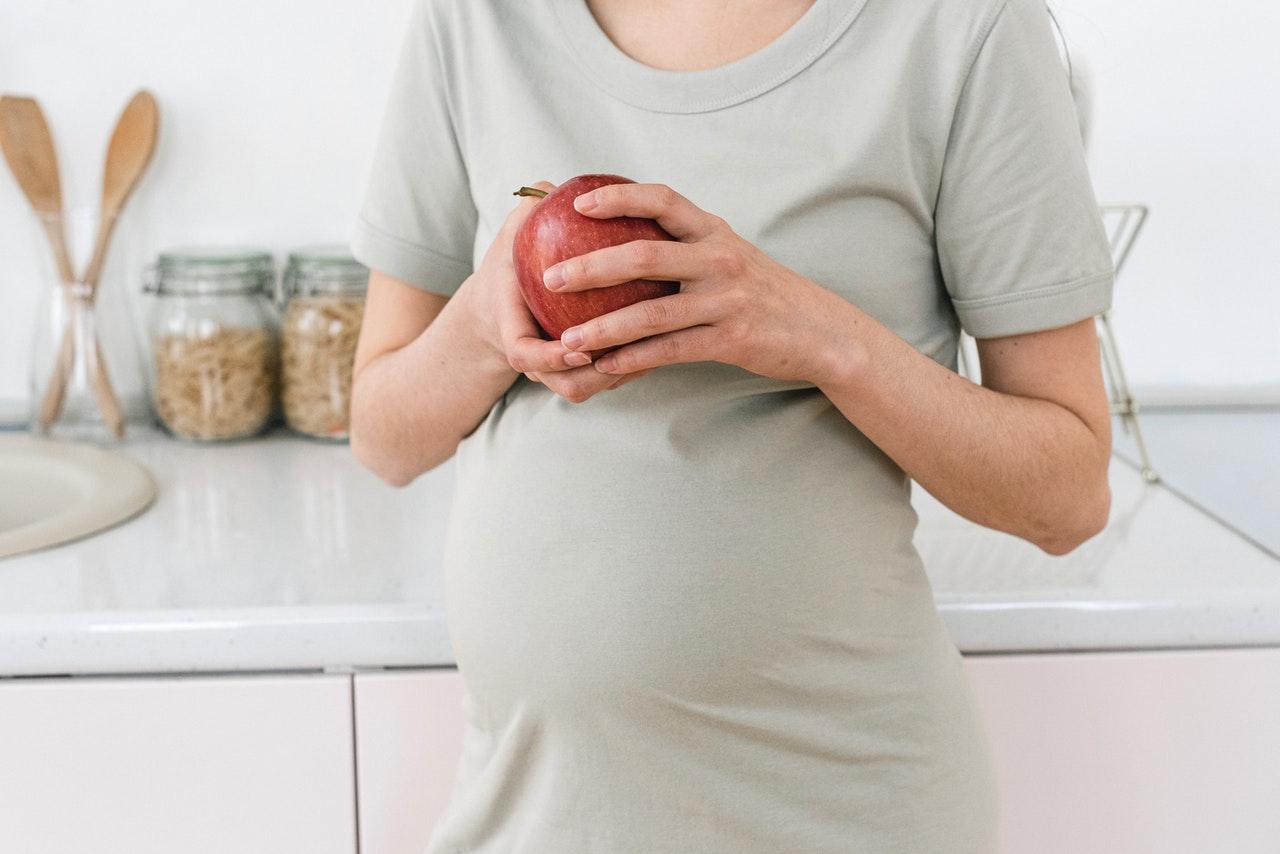 Pregnant women holding an apple